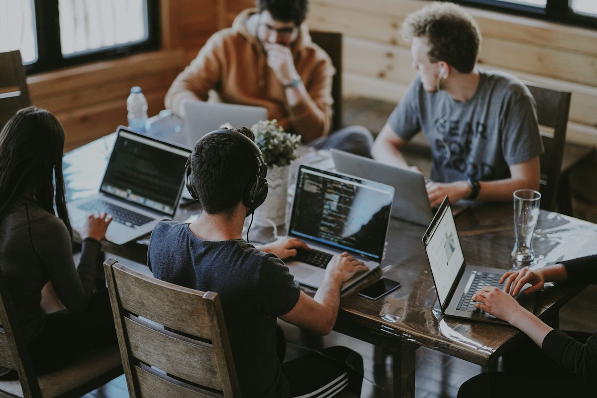 A team collaborating on laptops in a shared workspace